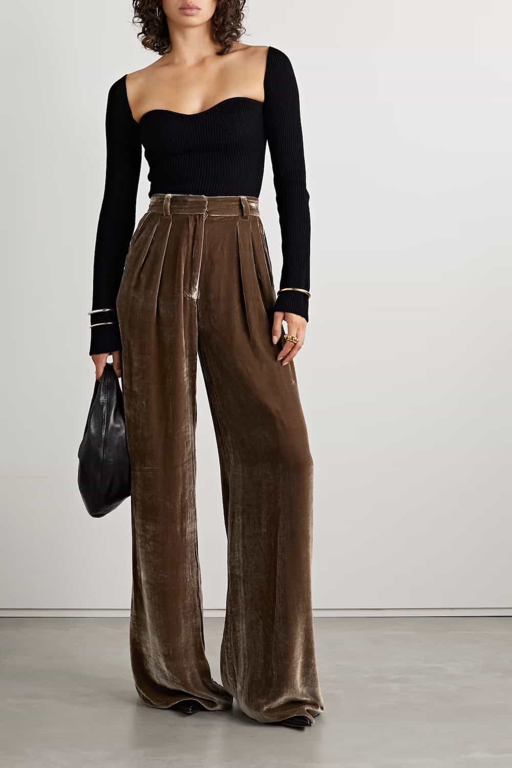 Woman in brown velvet trousers with a black long-sleeve top LA outfit