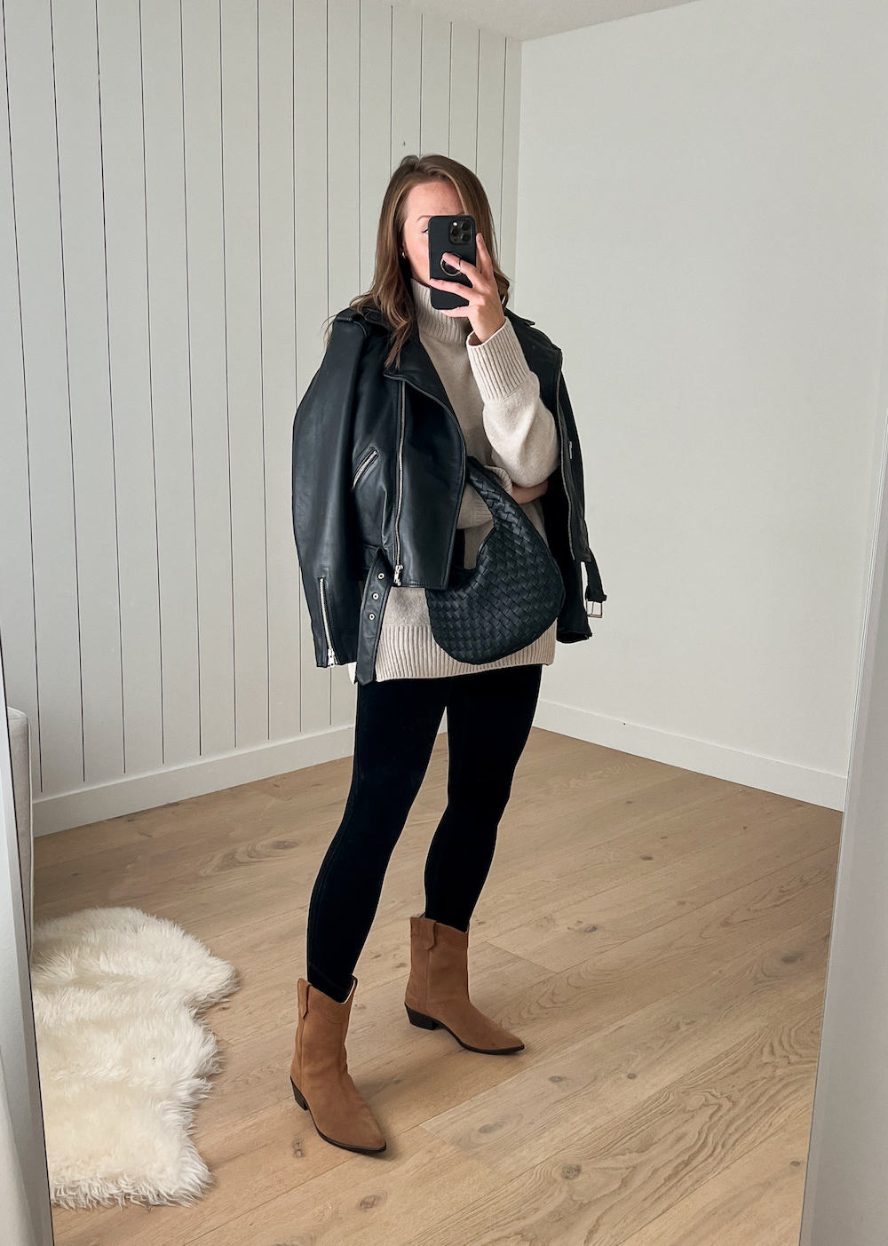 Woman wearing black velvet leggings with a sweater, leather jacket and boots LA outfit