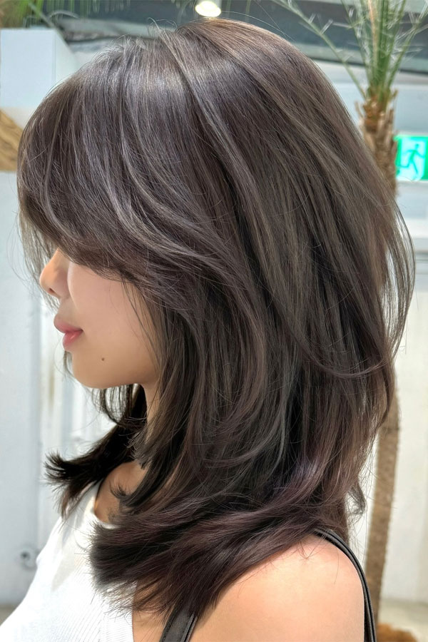 Full, Bouncy Layers Paired with Curtain Bangs layered hairstyle