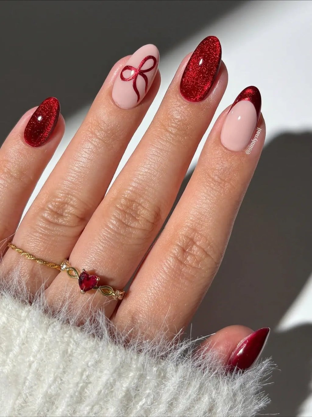 Sheer Pink Almond Nails with a Red Bow and Glitter holiday nail design
