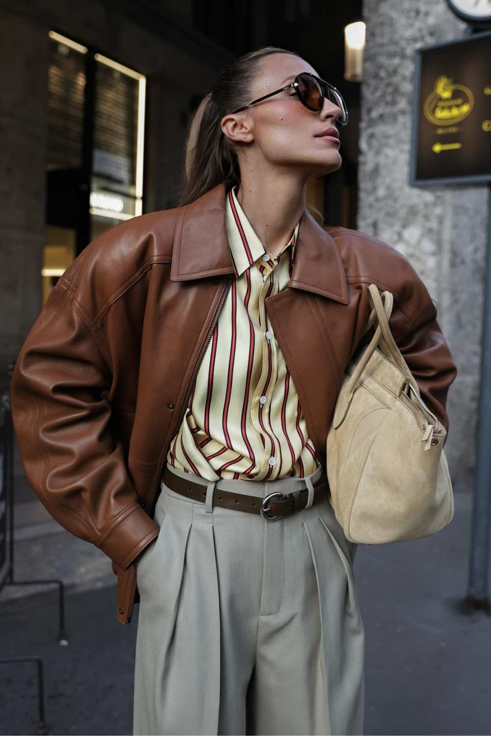 Cognac leather jacket worn with a striped silk shirt and grey pleated trousers