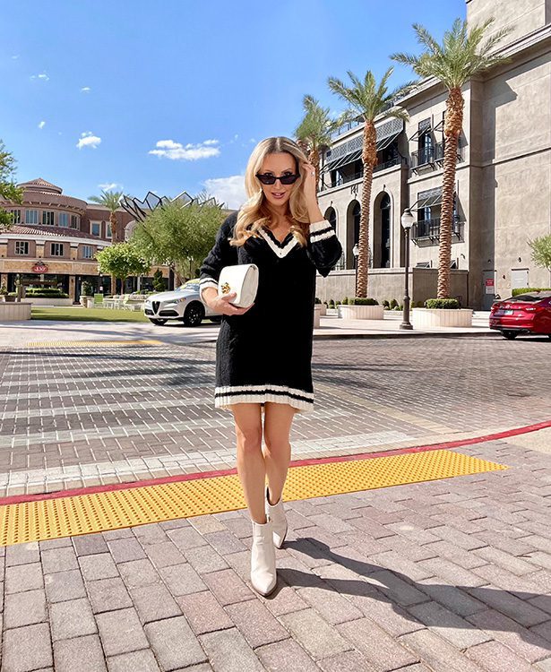 White ankle boots paired with a black sweater dress