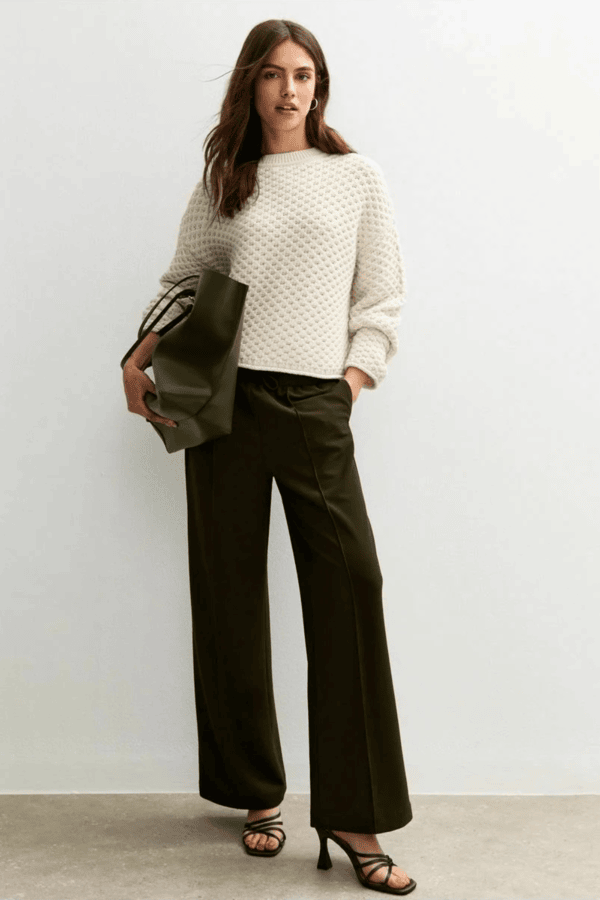 Textured white crewneck sweater with black wide-leg trousers