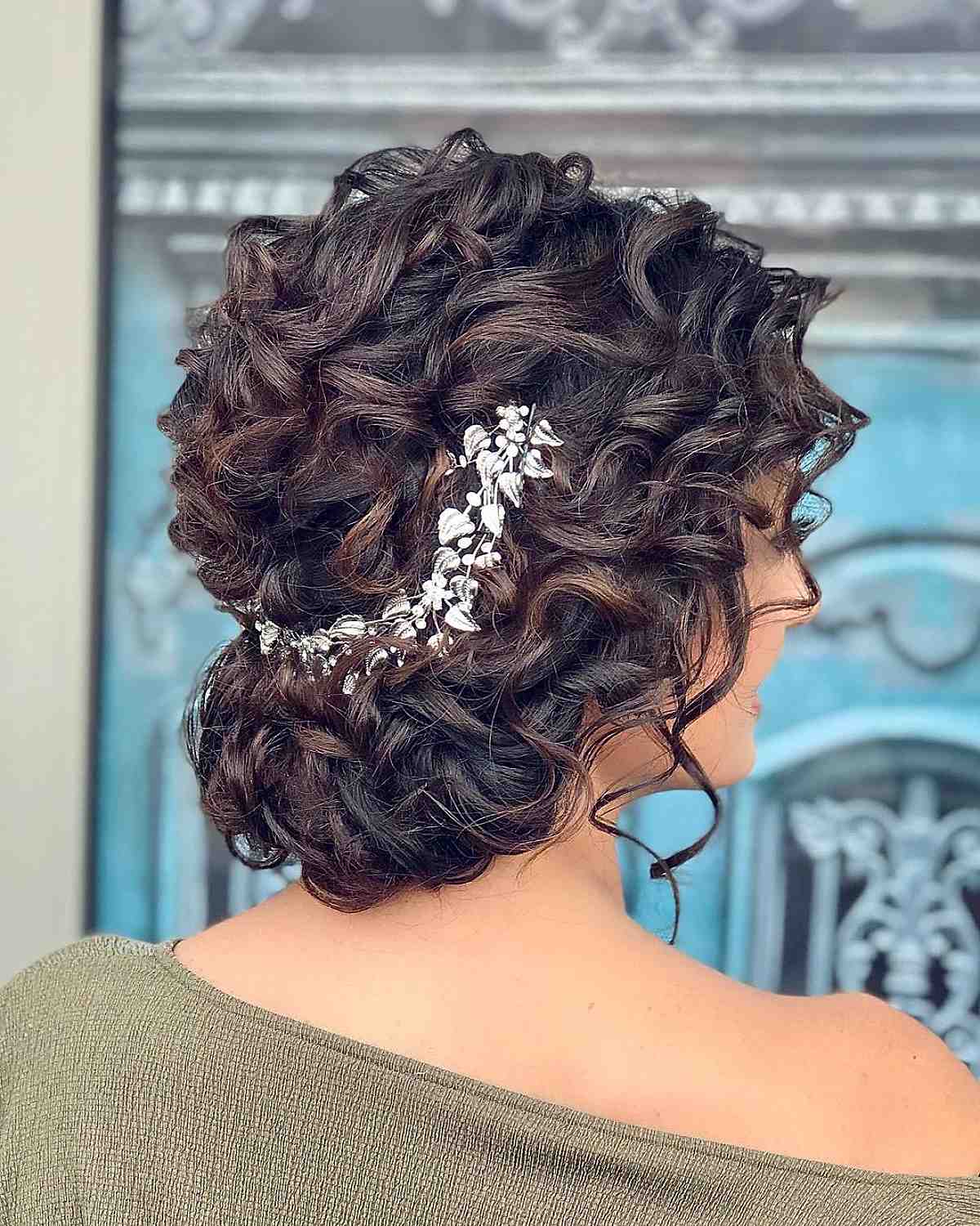 Loose curly updo finished with a delicate accessory