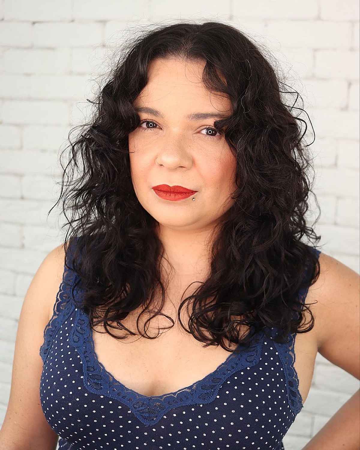 Dark curly mid-length shag haircut with rounded layers