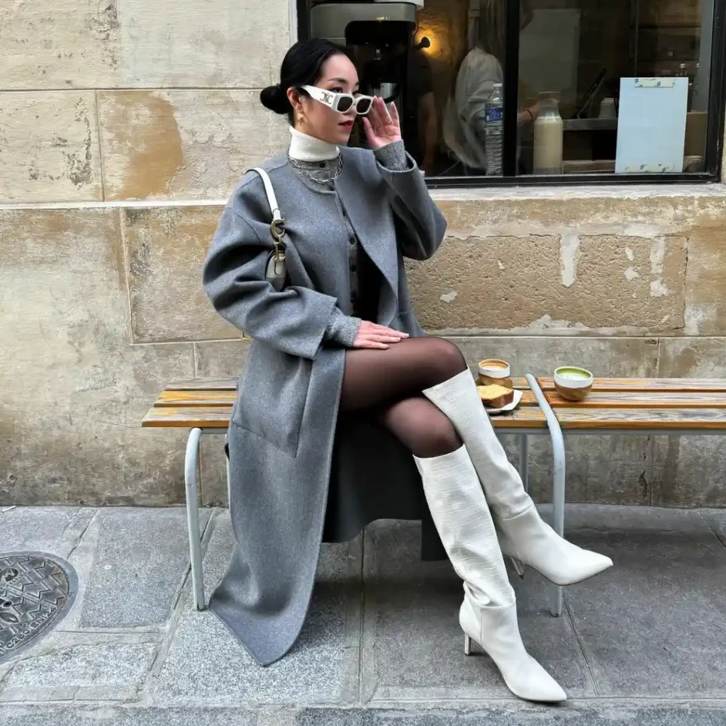 Long grey coat with tights and cream heeled knee-high boots
