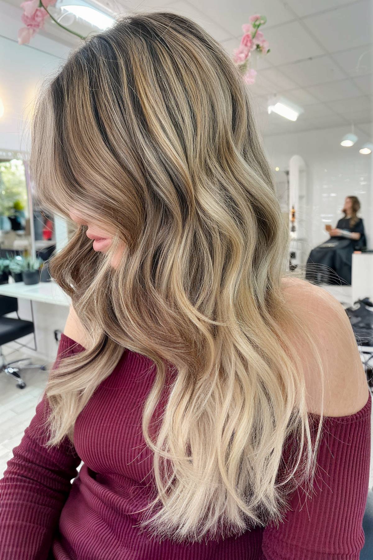 Natural ash blonde balayage on medium to long wavy hair