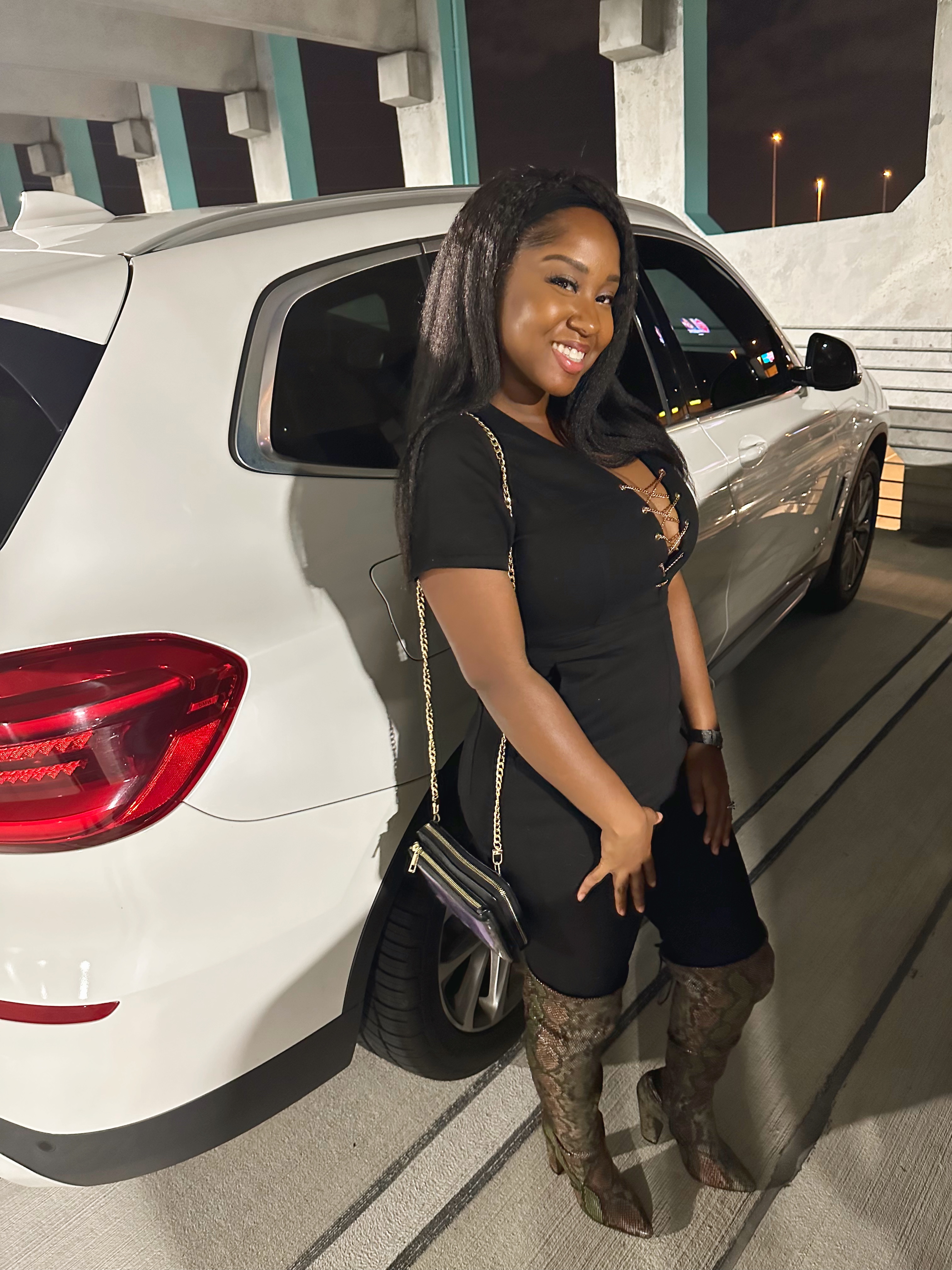 Black short-sleeve jumpsuit with snakeskin knee boots dinner outfit