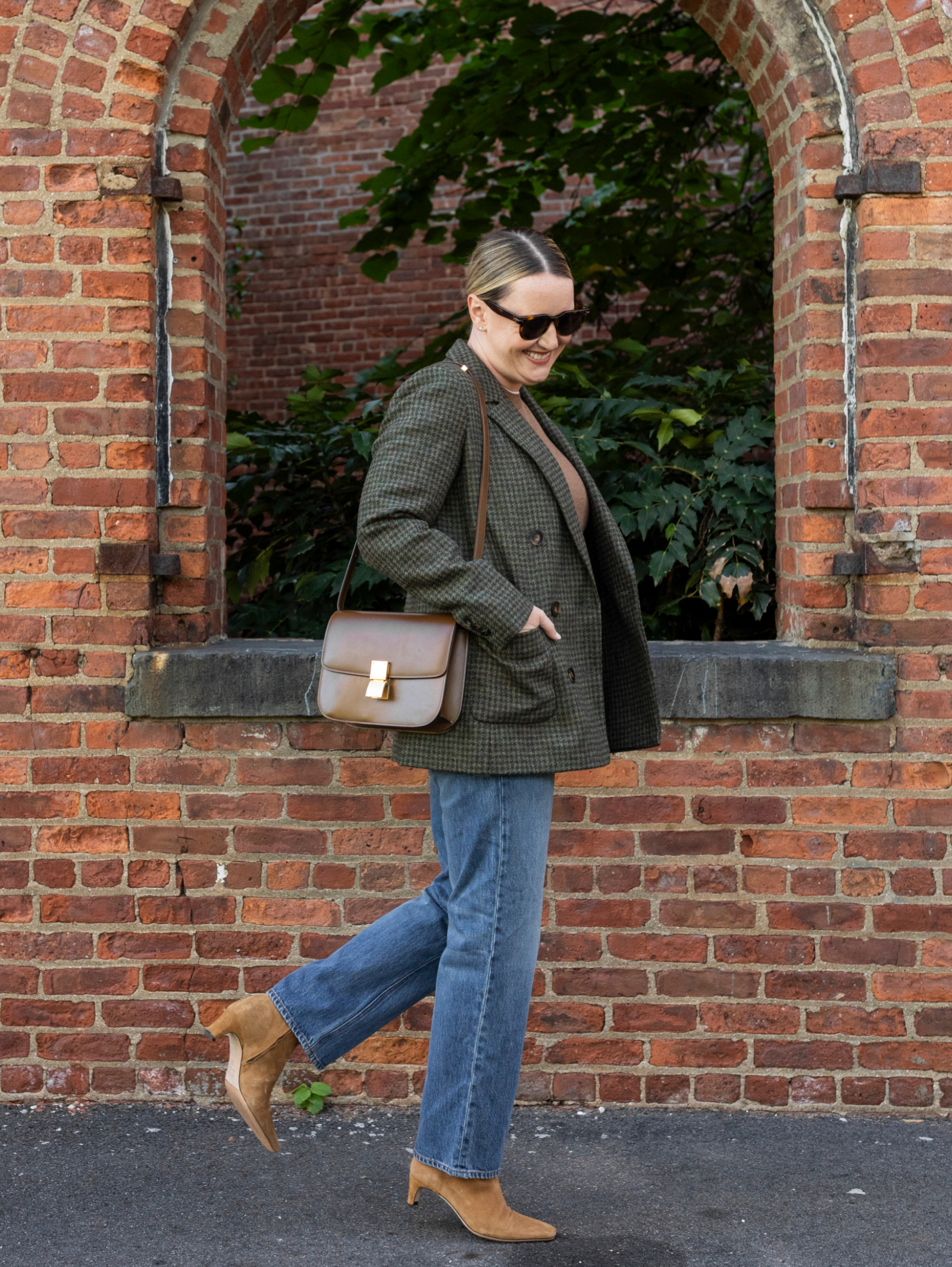 Woman wearing a plaid blazer with straight jeans and boots LA outfit