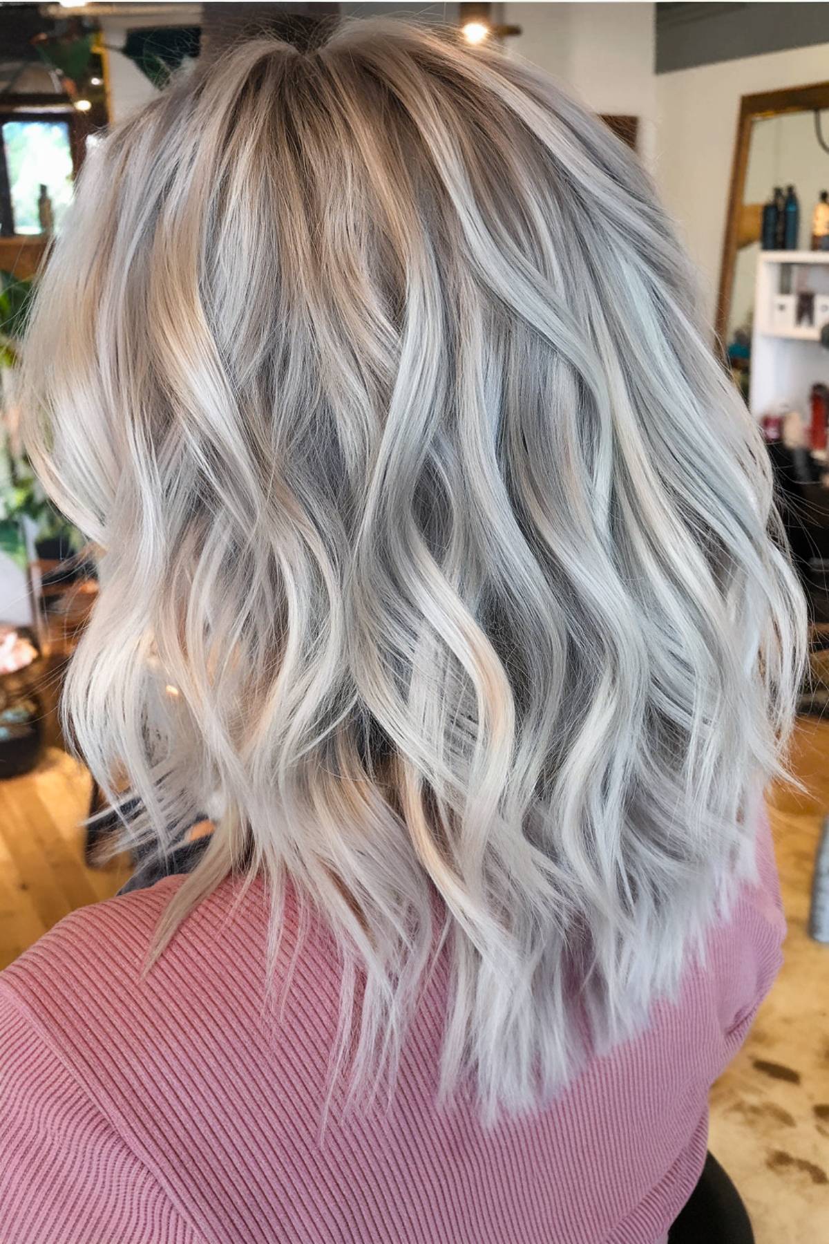 Platinum ash blonde balayage on layered wavy hair