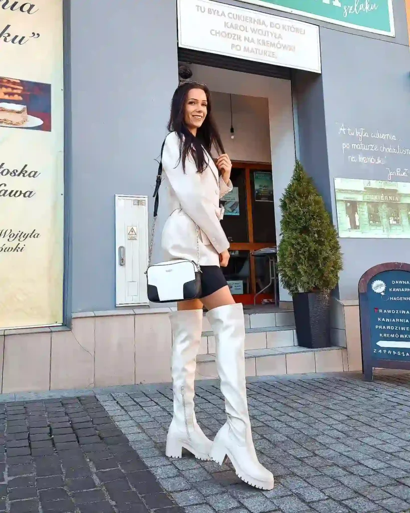 Oversized white blazer with biker shorts and white over-the-knee boots