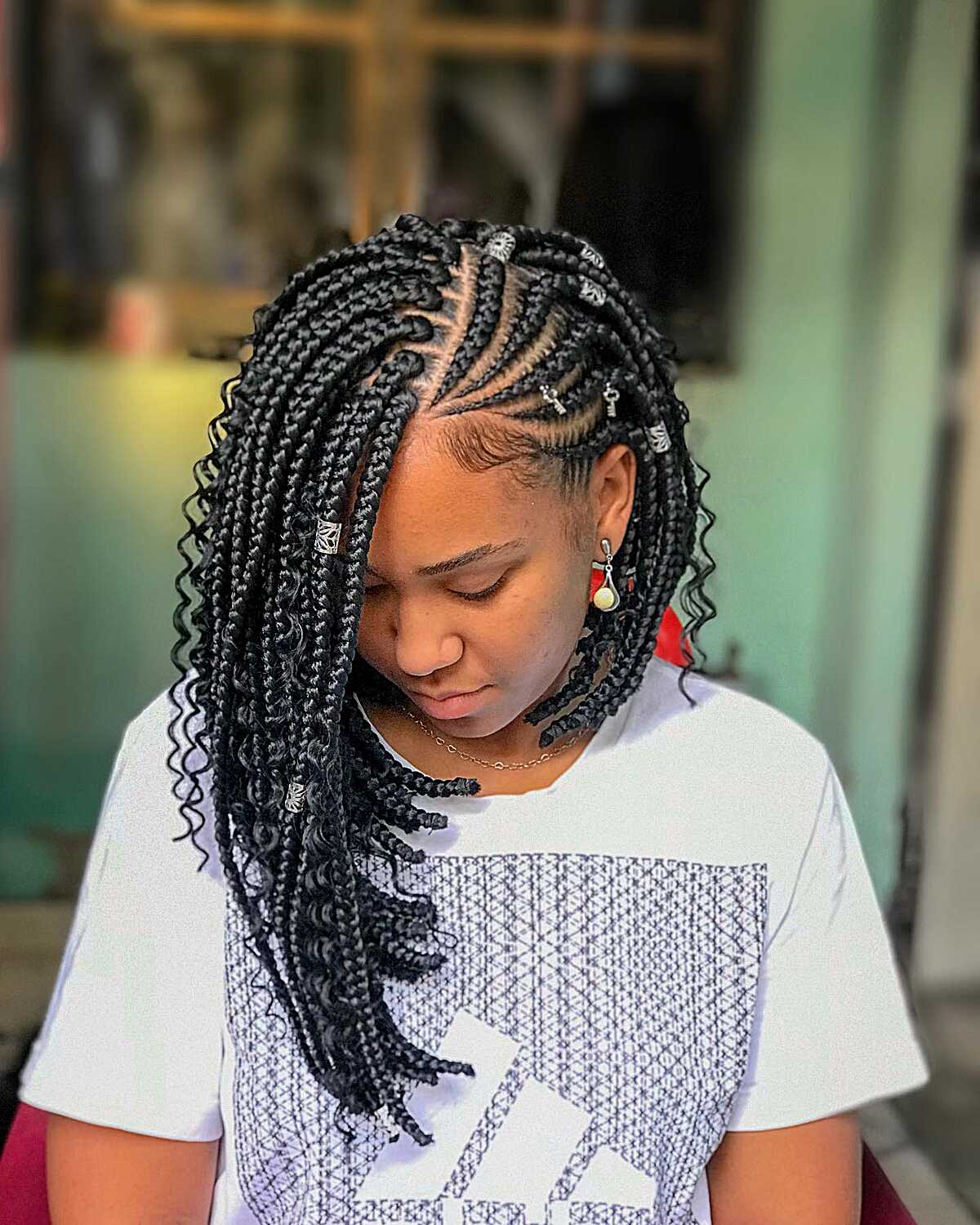 Geometric cornrows at the front flowing into box braids with curly ends braided style