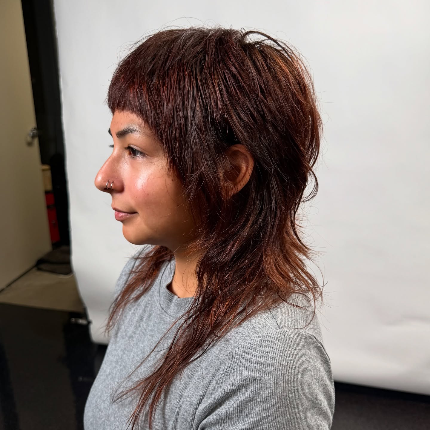 Auburn shag mullet with a blunted mini fringe and wispy feathered nape