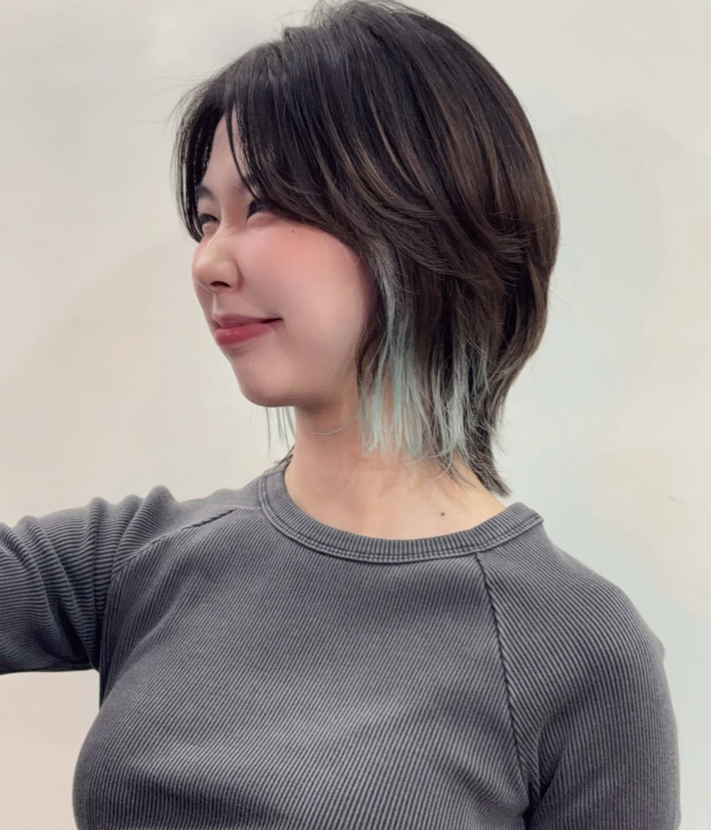 Textured short wolf cut with teal peekaboo underlayer