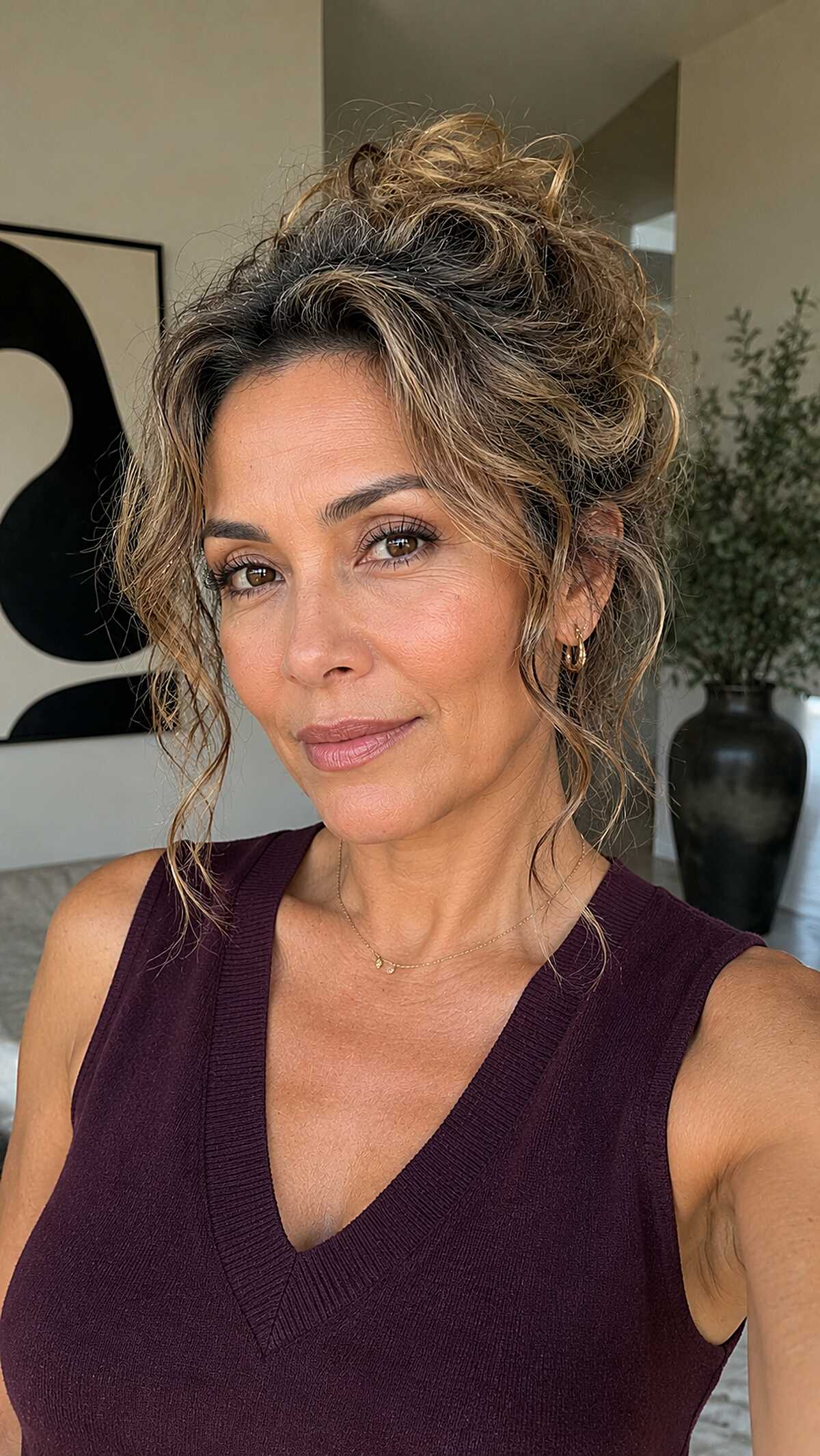 Tousled honey-toned curly pile updo with wispy ends