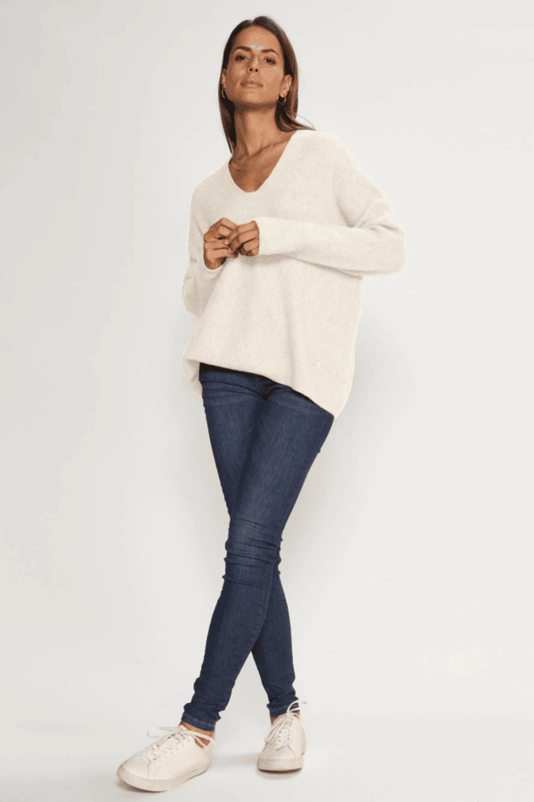 White V-neck sweater with skinny jeans and white sneakers