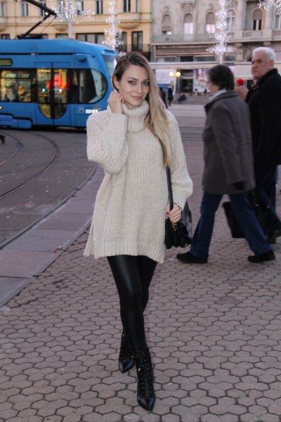 White turtleneck knit sweater with black leather leggings