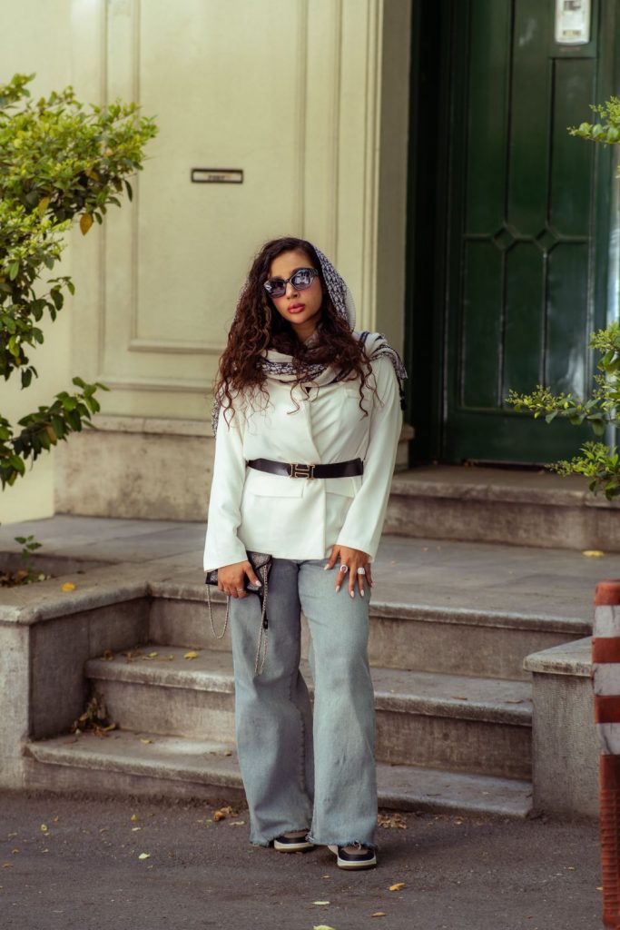 Woman in a white jacket with a black belt and light grey wide-leg jeans LA outfit